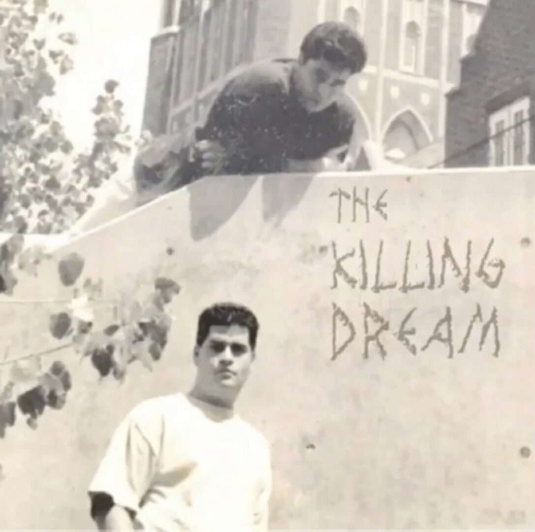 A man on top of a wall with the words " killing dream ".