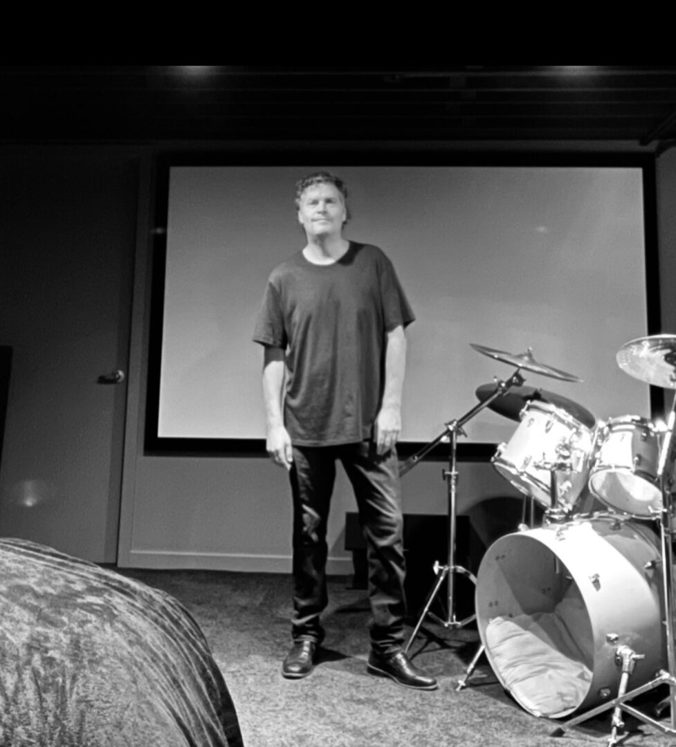 A man standing in front of a projector screen.